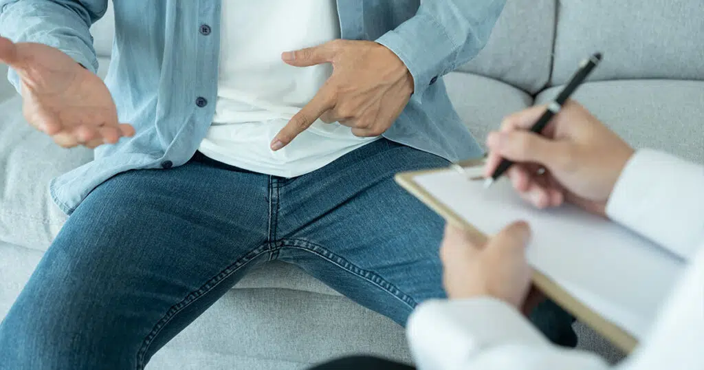 Male patient consulting doctor about male liposuction in the pubic area