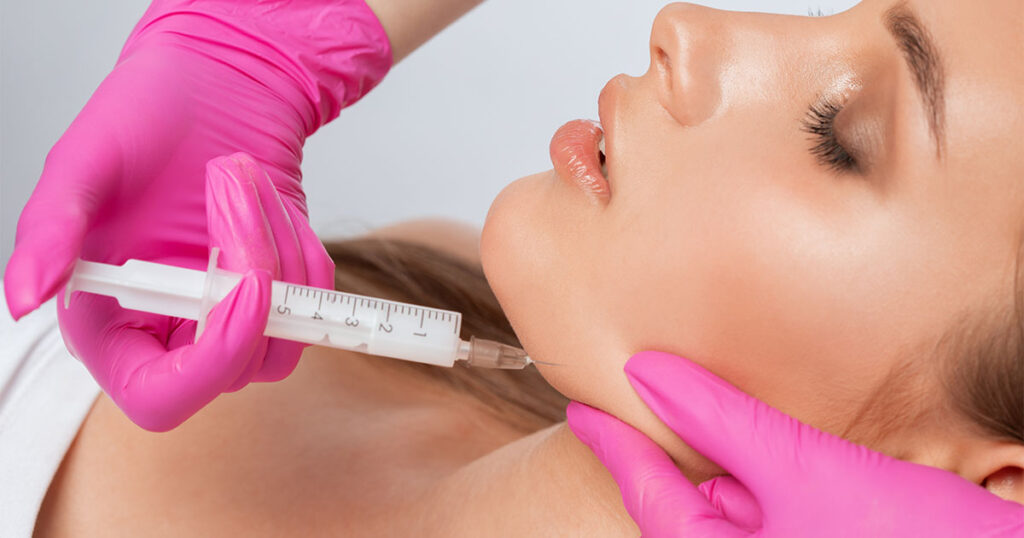 Woman getting injection to reverse buccal fat removal.