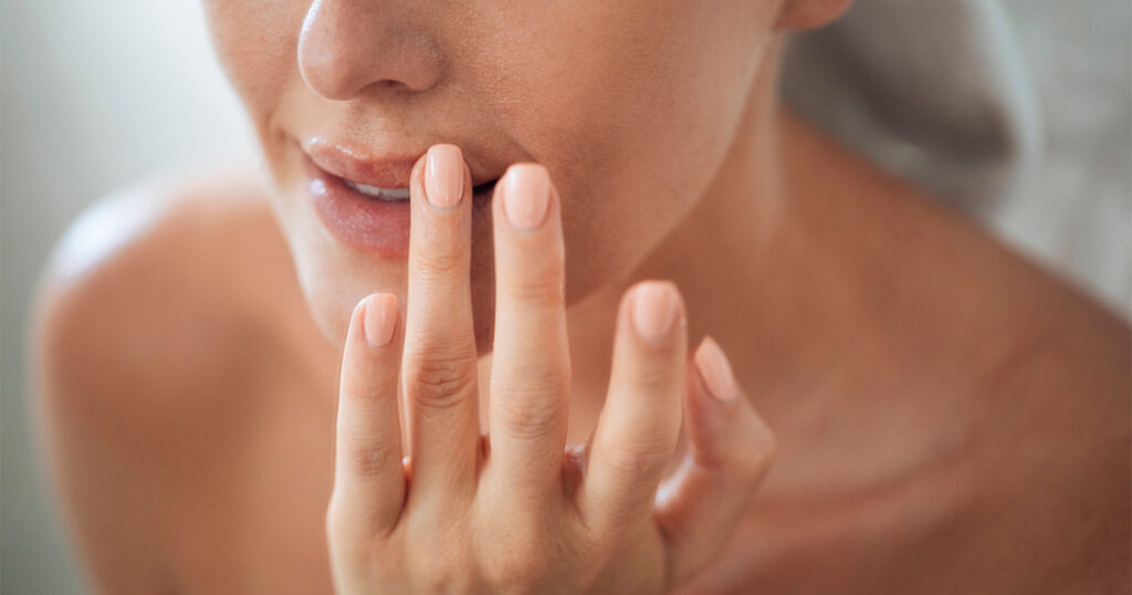 Woman touching her lip after recovering from lip lift surgery
