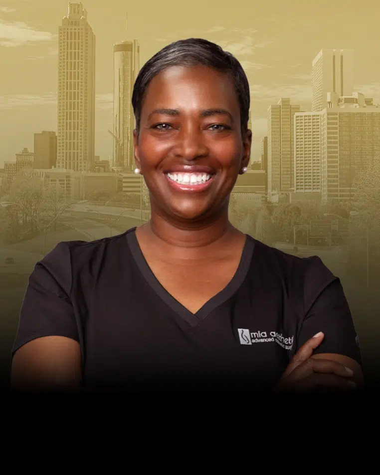 Dr. Myla Bennett in Mia Aesthetics scrubs, with the Atlanta skyline behind her
